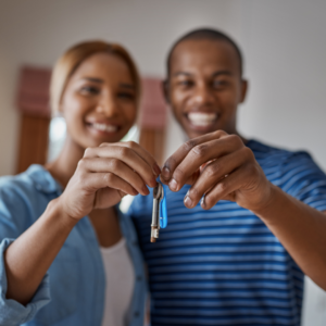 6 Types of People That Need Solar in Their Lives 17 A smiling couple holding up a key together, symbolizing a new home or solar ownership