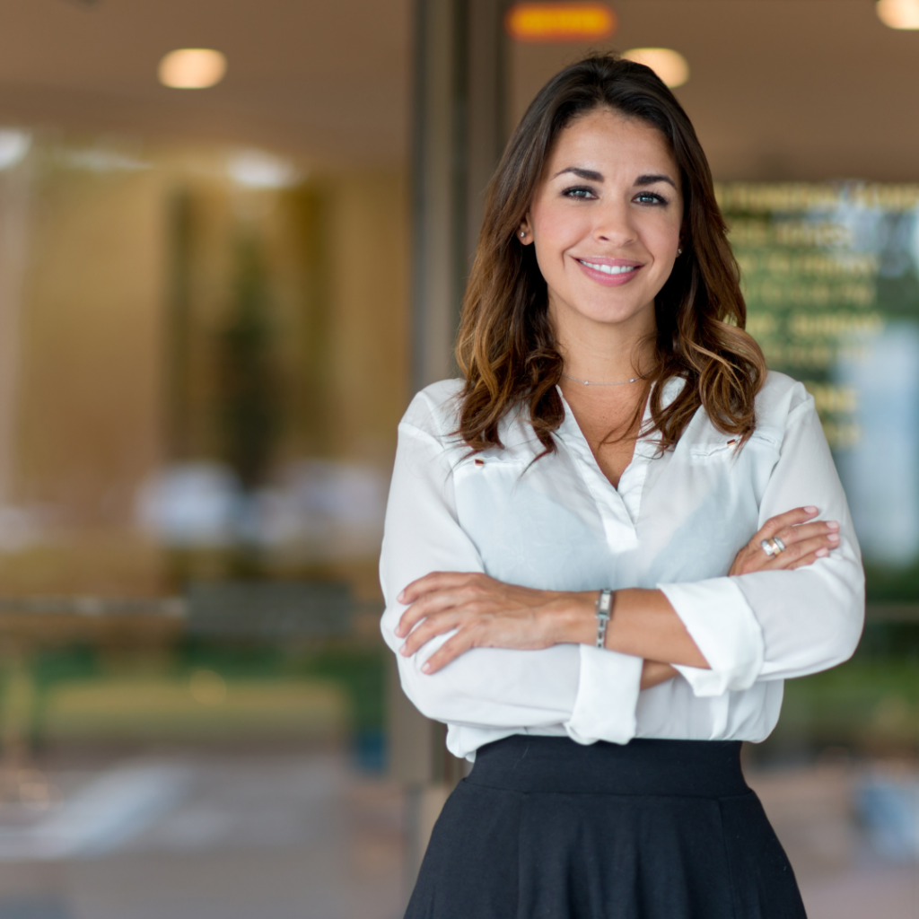 Confident professional woman standing with arms crossed in an office environment focused on solar energy.