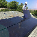 worker adding removing solar panel rooftop roof house